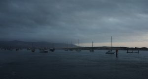 video still of bay at twilight with sailboats